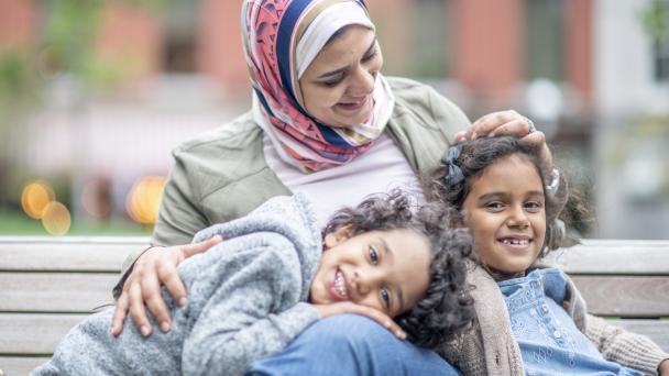 Muslim woman smiling with two children