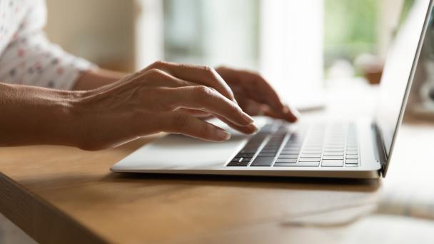 Hands of woman typing on keyboard